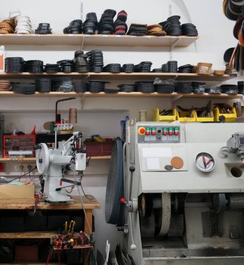 Ayakkabı endüstrisinin üretim hattında ayakkabı üreten erkek işçi. Erkek ayakkabıcı atölyesinde deri tekstil ile çalışıyor.