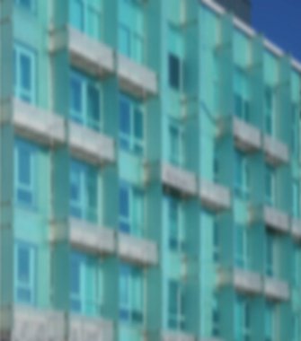 Modern mimarinin soyut bir parçası, camdan ve betondan yapılmış duvarlar. Modern mavi ve yeşil balkonlu bina