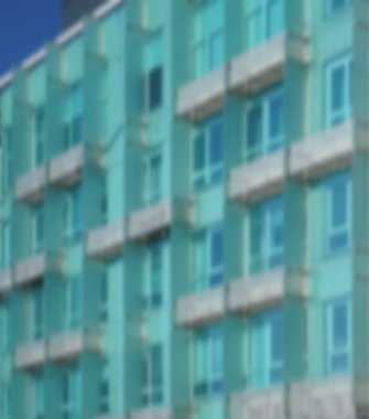 Modern mimarinin soyut bir parçası, camdan ve betondan yapılmış duvarlar. Modern mavi ve yeşil balkonlu bina