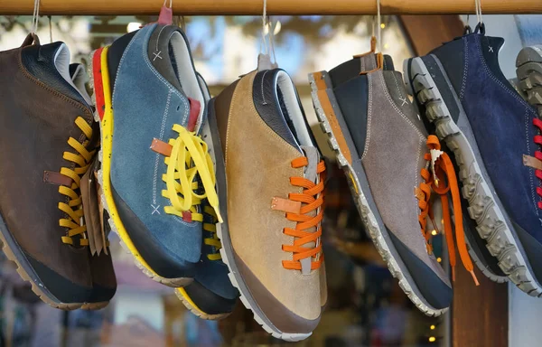 Fashion male sport shoes hanging on store background. Stylish, colorful  man sneakers for walking, close up.
