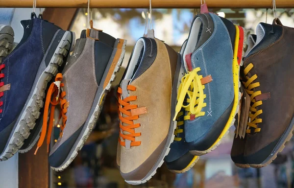 Fashion male sport shoes hanging on store background. Stylish, colorful  man sneakers for walking, close up.