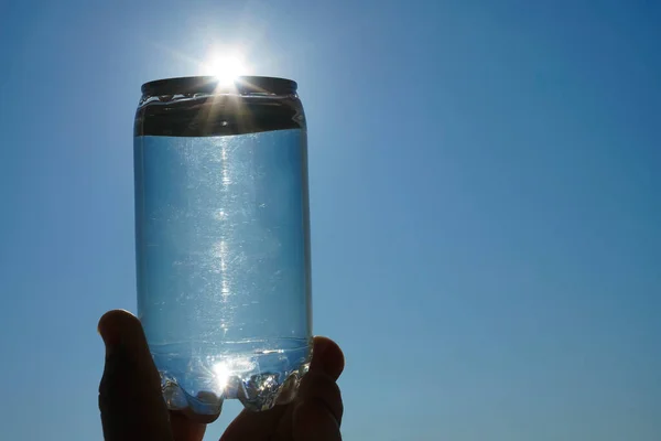 Menschliche Hand Hält Eine Wasserflasche Gegen Die Untergehende Sonne Nahaufnahme — Stockfoto