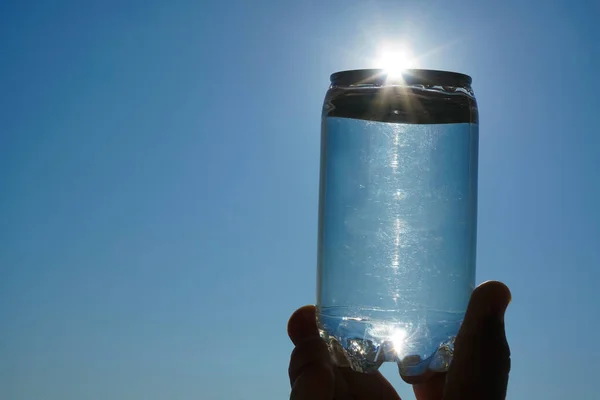 Ludzka Ręka Trzymająca Butelkę Wody Przed Zachodzącym Słońcem Zamknij Się — Zdjęcie stockowe