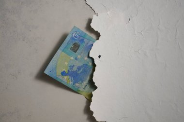 Euro banknotu duvardaki çatlağa yerleştirilmiş. alçı beton duvardan düşer.