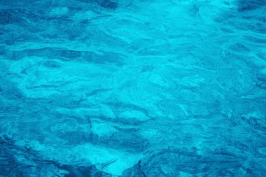 Okyanustaki su altı turkuaz dokusu. Tropikal denizde kabarcıklar. Dalgalı derin turkuaz ve mavi Akdeniz, beyaz köpük desenli arka plan