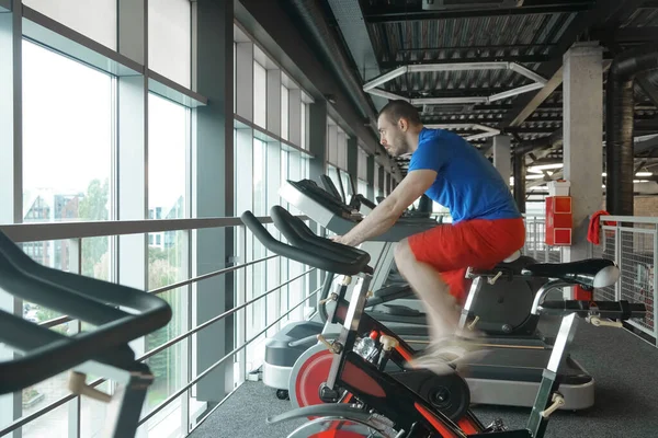 Muskulös Man Som Använder Spinning Cykel Gym Cykelkonditionsträning Gymmet Sidovy — Stockfoto