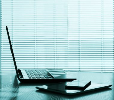 Aksesuarları ve mesafelere sahip serbest masa üstü bilgisayarı, dizüstü bilgisayarı ve dijital tableti, cep telefonu, iş yeri ya da ev ya da ofis. kör pencere arkaplanı.