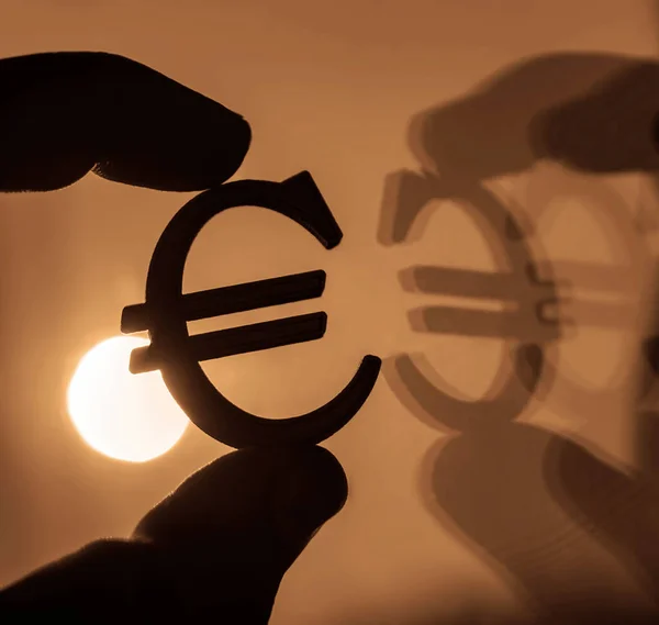 golden European Currency Symbol or Sign Euro With Mirror Reflection on sunset sky  Background