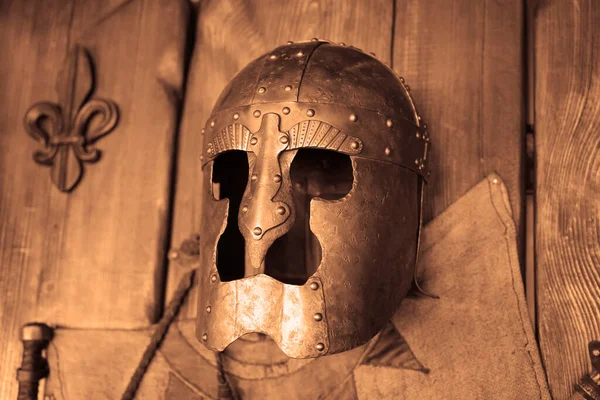 Roman helmet on a wooden wall  background