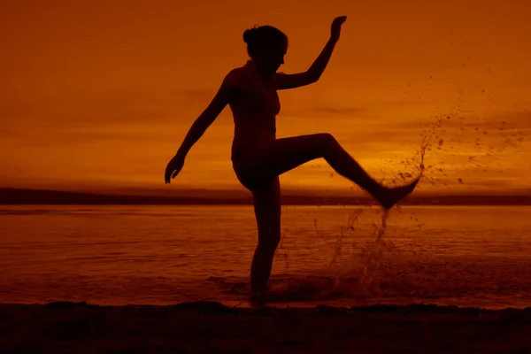 ビーチで水に飛び込む若い女性のシルエット — ストック写真