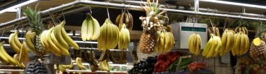 Marketin raflarına çeşitli sebze ve meyveler serildi. Çevirisi: biber, domates, ananas demeti muz. İspanya, Barcelona 'daki Boqueria pazarı