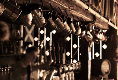 Barmen ayakta, büyük bir fincana bira dolduruyor. Bira bardağına odaklan. Bar bira bardağı bira fıçısı. 