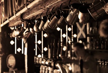 Barmen ayakta, büyük bir fincana bira dolduruyor. Bira bardağına odaklan. Bar bira bardağı bira fıçısı. 