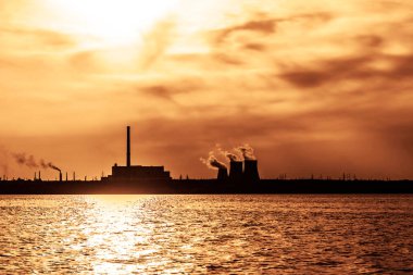 CHP kuleleri, soğutma kuleleri. Mavi gökyüzüne karşı endüstriyel gaz borusu. Rusya 'da üretim fabrikası. Kirlilik, duman ve buhar bir sanayi tesisinden boşaltılıyor.                        