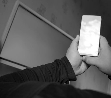 Çalışma masasında cep telefonu tutan adam. boş ekran. boş kopyalama alanı. maketleme