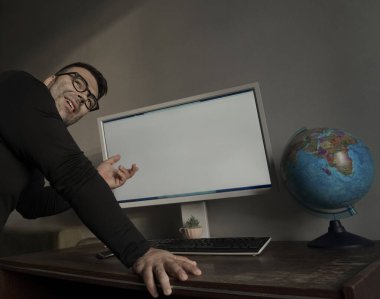İş adamı iş sunumu için boş bilgisayar ekranı sunar. E-öğrenme konsepti: kişisel bilgisayar ekranında online okul. Duvarda güneşli bir ışık.
