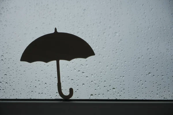 Window with raindrops. sign, symbol of umbrella. rainy weather.