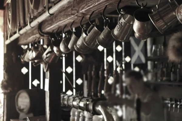 Bartender man standing, pouring beer into a large cup. Focus on the beer cup. bar pub beer cup  draft beer.