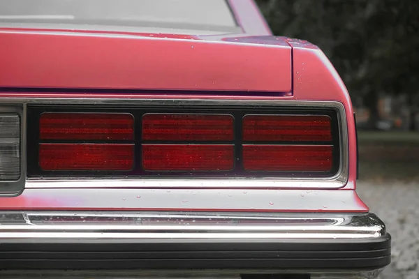 색이나 분홍색 빈티지 브레이크 라이트 자동차의 세단의 후미등 비오는 가을철 — 스톡 사진