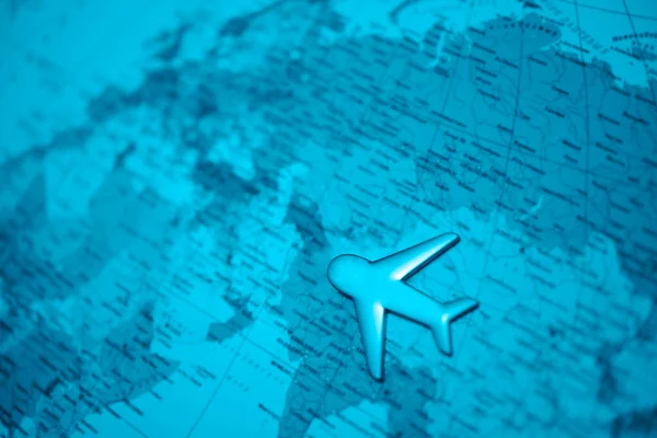 Travel with plane, small toy plain on globe map background, traveling and logistic  concept