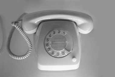 Beyaz arkaplanda izole edilmiş, eski, gri bir telefon.