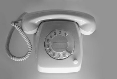 Beyaz arkaplanda izole edilmiş, eski, gri bir telefon.