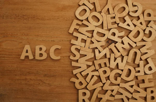 木制表面上的立方体字母 散落在英文字母表中以白色为背景的混合褐色木制字母 复制空间 作为背景组成 — 图库照片