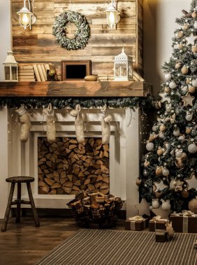Noel ağacı ve şöminesi olan bir tasarım odası. İç mekan eko tarzı. Noel süslemeli kanepe ve Noel ağacı, modern ve rahat. Mutlu yıllar ve mutlu Noeller.