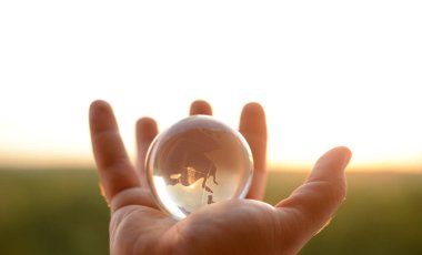 Güneşli gökyüzünde ve yeşil ormanda saydam gözlüklü Globe insan elinde. Çevre koruma kavramı. güneş ışığı. 