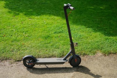 Yeşil çimen arka planında yeni bir elektrikli scooter. Yaz parkı. 