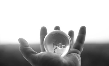 Güneşli gökyüzünde ve yeşil ormanda saydam gözlüklü Globe insan elinde. Çevre koruma kavramı. güneş ışığı. 