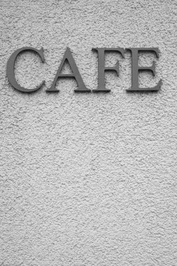 Kelime için gümüş harfler - beyaz desenli bir duvarda CAFE.