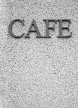 Kelime için gümüş harfler - beyaz desenli bir duvarda CAFE.