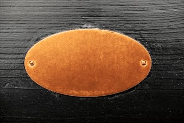 Ahşap kapı ya da arka planda altın oval metal işareti.