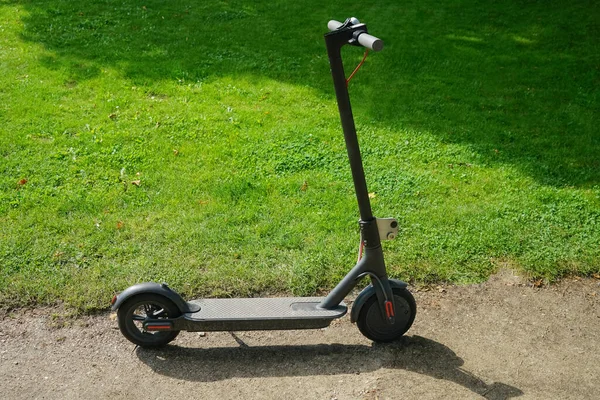 Yeşil çimen arka planında yeni bir elektrikli scooter. Yaz parkı. 