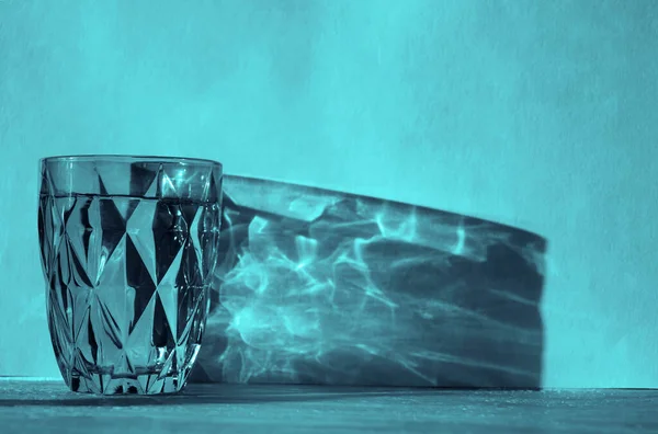 Vatten Glas Med Stark Skugga Solig Vägg Bakgrund Blått Fasetterat — Stockfoto