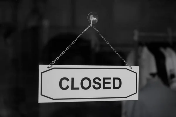A sign hanging off clothing store door, Close sign blur background, Label word close.