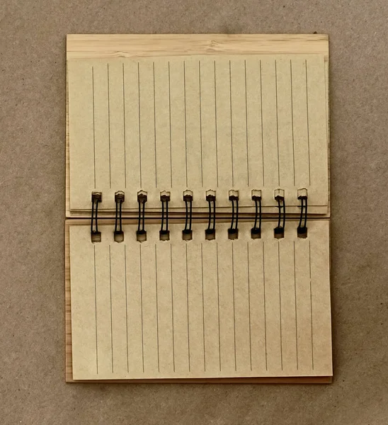 brown note pad in a wooden frame. top view. empty blank. craft paper packground.