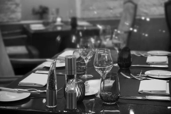 Edények Villák Kések Poharak Tányérok Asztal Tetején Homályos Éttermi Háttérrel — Stock Fotó