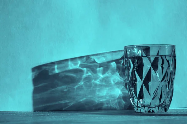 Güneşli Duvar Arka Planında Koyu Gölgeli Bardağı Mavi Yüzlü Cam — Stok fotoğraf