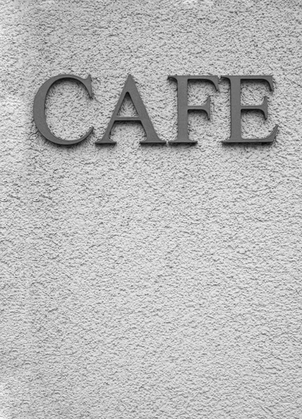 Kelime için gümüş harfler - beyaz desenli bir duvarda CAFE.
