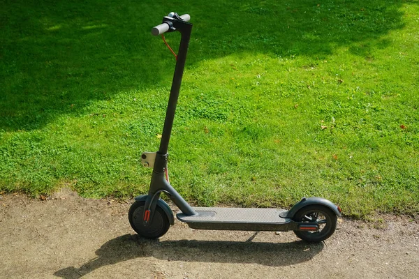 Yeşil çimen arka planında yeni bir elektrikli scooter. Yaz parkı. 