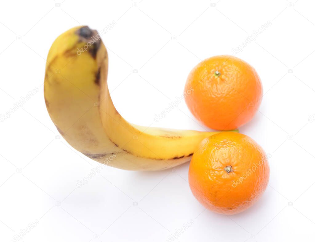 A flat lay of ripe banana and two fresh mandarines represent a penis concept. isolated on white background. male genitals