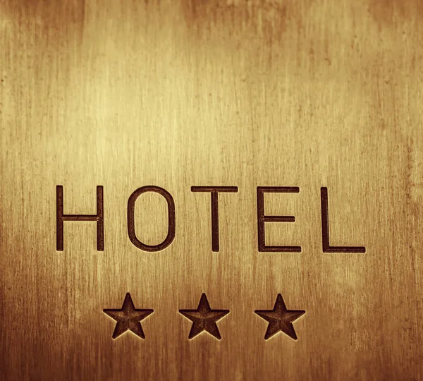HOTEL  signboard with  three 3 stars metallic plate next to entrance door. 3 three  golden stars. empty copy space for inscription.