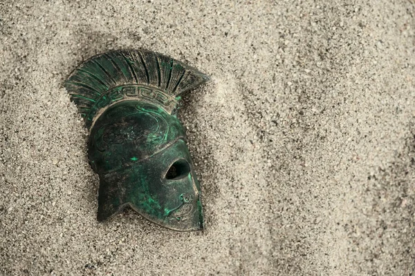 helmet of ancient warrior in sand. Roman Legionar