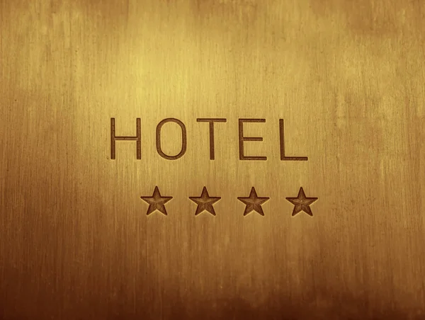 HOTEL  signboard with  four 4 stars metallic plate next to entrance door. 4 four golden stars. empty copy space for inscription.