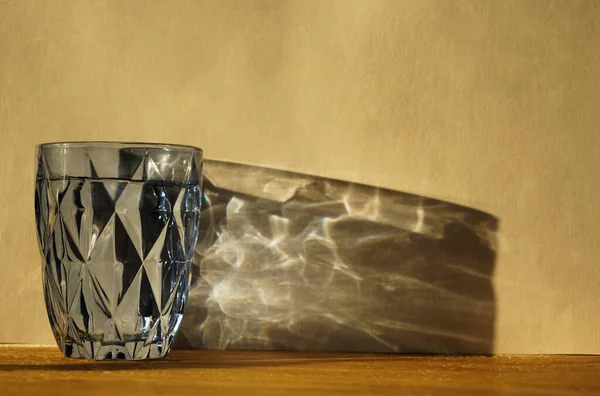 Vidrio Agua Con Sombra Fuerte Sobre Fondo Pared Soleado Vidrio —  Fotos de Stock
