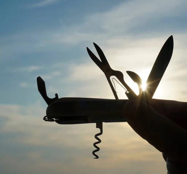 Silueta Una Mano Que Sostiene Cuchillo Multifunción Plegable Contraluz Atardecer — Foto de Stock