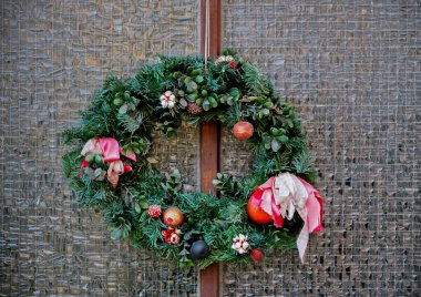 Gözlük kapısında Noel çelengi. Bir dükkanın ya da evin ön kapısında ladin ve süs eşyalarından yapılmış el yapımı geleneksel bir Noel çelengi asılı. Yeni yıla hazırlık konsepti..