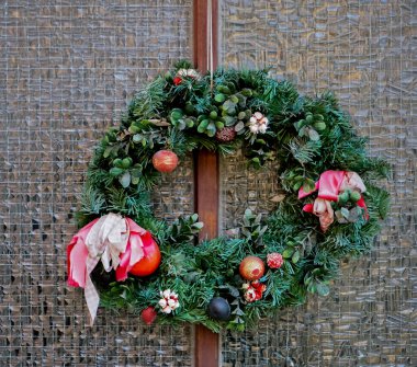 Gözlük kapısında Noel çelengi. Bir dükkanın ya da evin ön kapısında ladin ve süs eşyalarından yapılmış el yapımı geleneksel bir Noel çelengi asılı. Yeni yıla hazırlık konsepti..